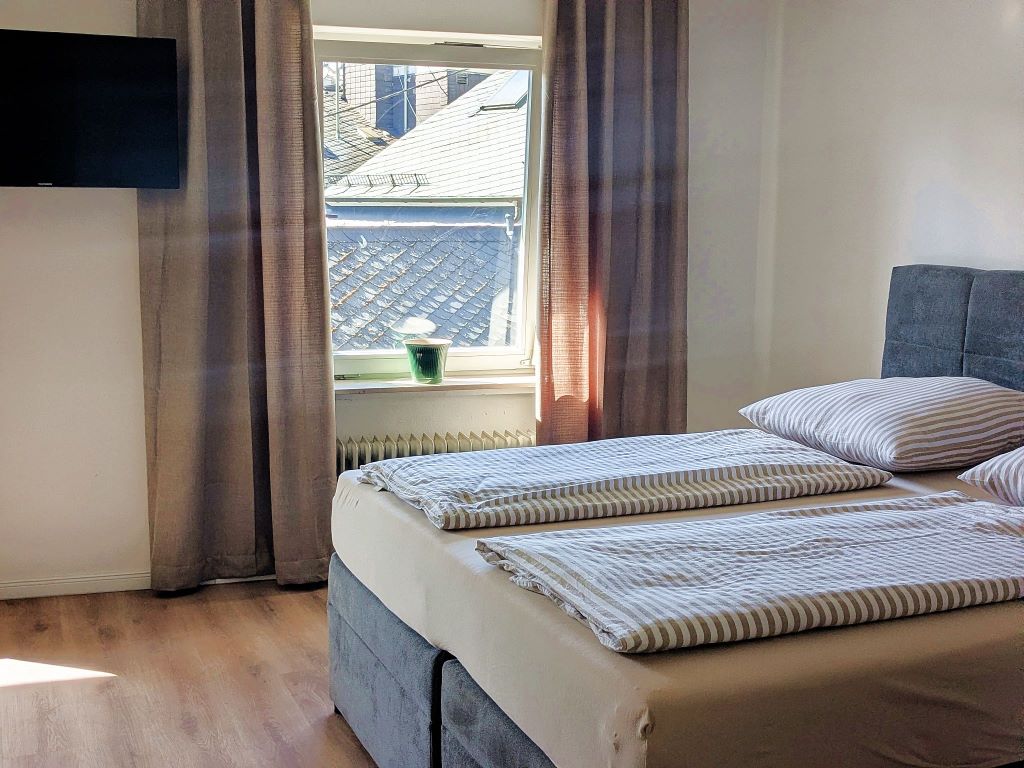 Doppelbett mit Fernseher - Urlaub an der Mosel in Ferienapartment Collis in Gästehaus Zeller Altstadt, Oberstraße 6, 56856 Zell (Mosel)